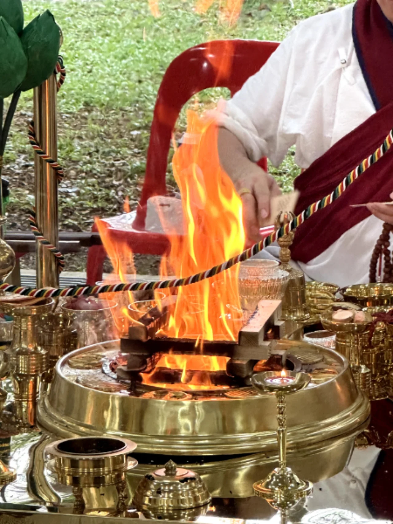 Flames rising from a brass vessel during a fire offering.